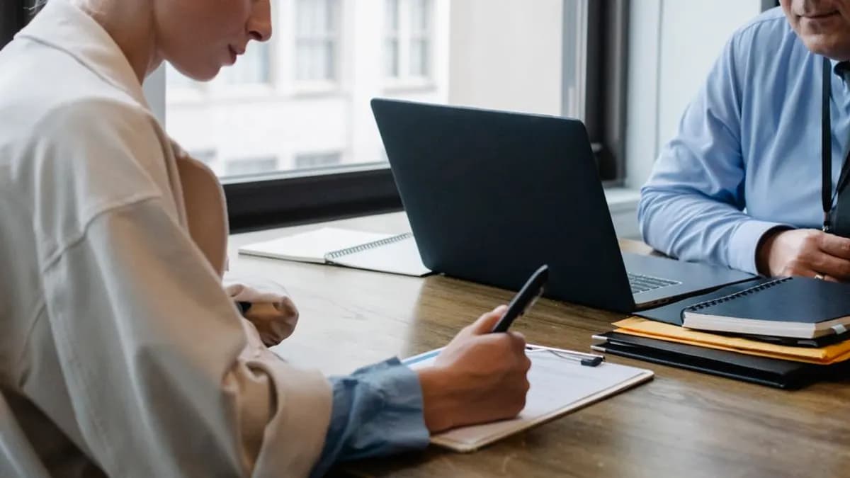 Business partners signing a contract at a desk in the office